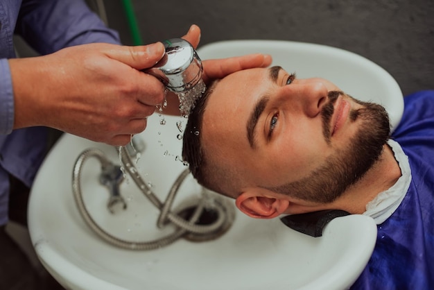 Hairstylist washing client39s hair in a barber shop Selective focus High quality photo