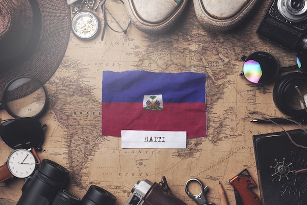 Haiti Flag Between Traveler's Accessories on Old Vintage Map. Overhead Shot