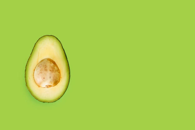 Half avocado on a green background