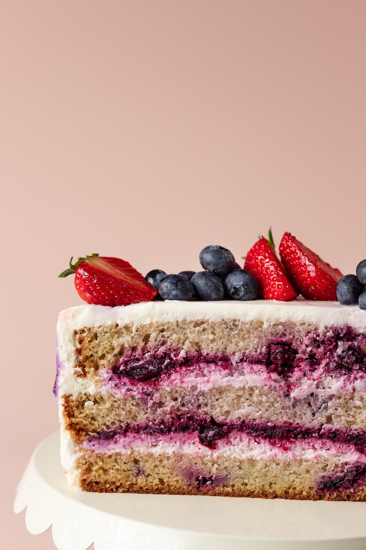 Фотография половинка черничного торта украшена свежими ягодами вкусный торт на день рождения