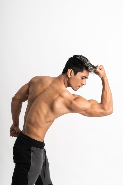 Half body image of young man showing muscular biceps stand facing forward