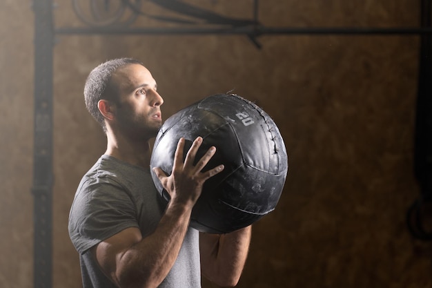 Half body portrait of muscular man working out with medicine ball