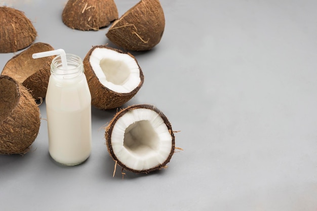 Foto metà bottiglia di latte di cocco con paglia yogurt di cocco in ciotola