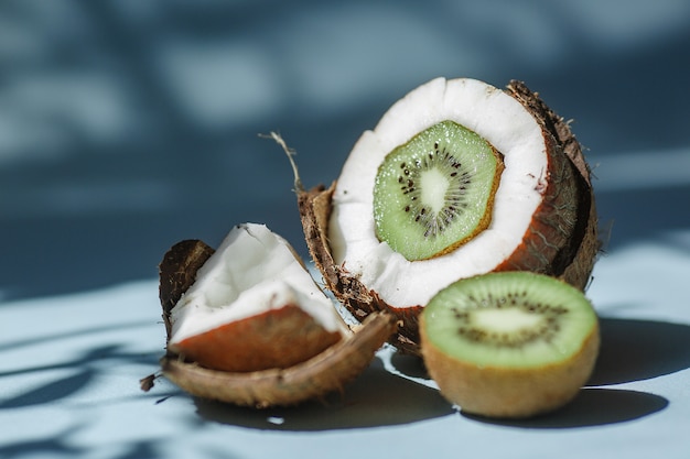 Half a coconut with kiwi and pieces of coconut