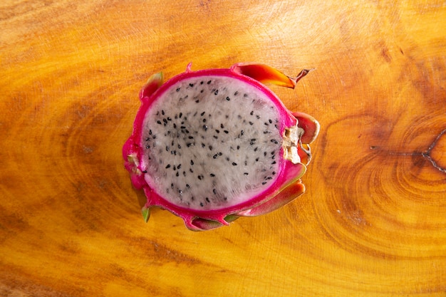 Photo half of dragon fruit on rustic wooden background. pitaya or dragon fruit. exotic tropical fruit.