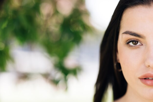 half face of beautiful soft woman with natural makeup looking at camera