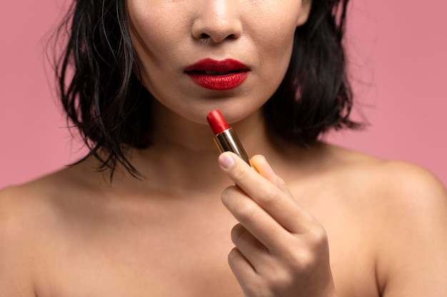 Half face view of brunette asian woman with short hair and red lips