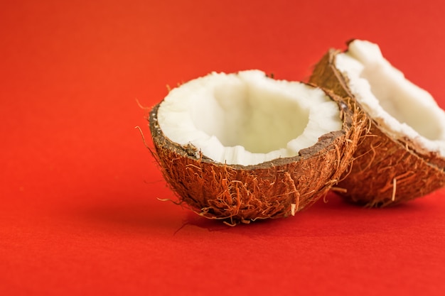 Half of fresh raw coconut  on red backgound.