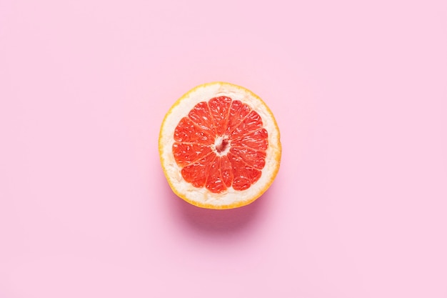 Half grapefruit on a pink background.