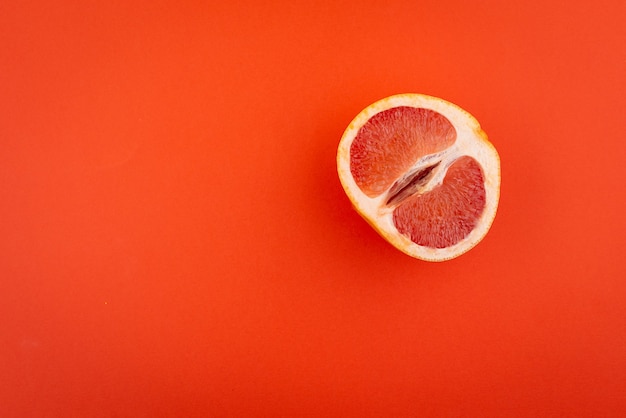 Half grapefruit on a red surface