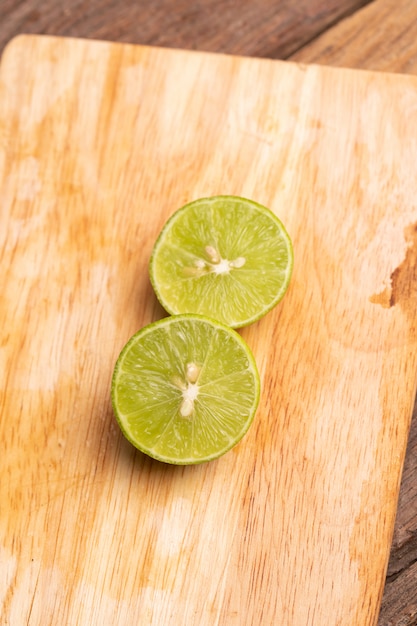 A half of the green lime place on wooden board