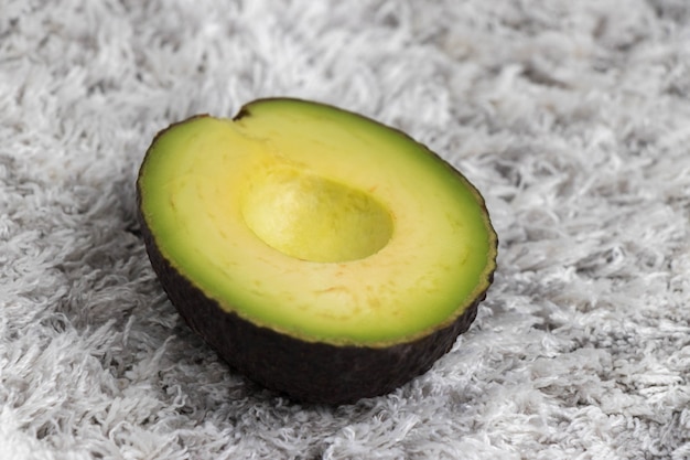 Half groene gesneden avocado op tapijt