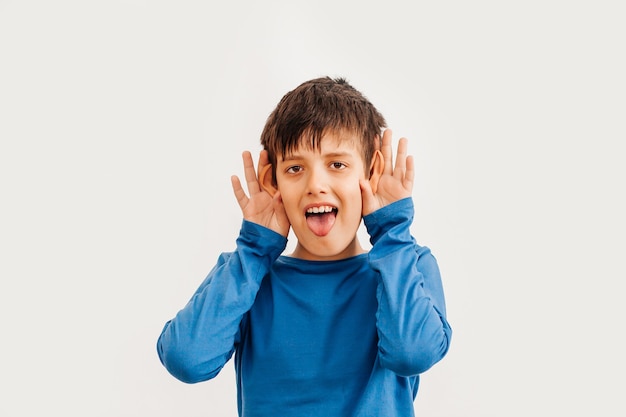 Half-lengte emotioneel portret van Kaukasische tienerjongen die blauw t-shirt draagt. Verrast tiener camera kijken. Knap gelukkig kind, geïsoleerd op een witte achtergrond.