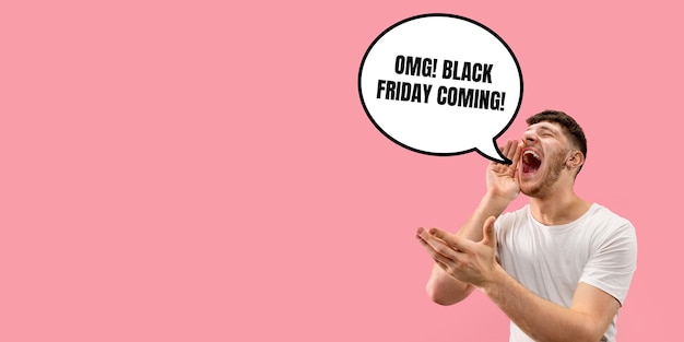 Half-length close up portrait of young man on coral background. The human emotions, black friday, cyber monday, purchases, sales concept. Trendy colors. Negative space. Screaming, crazy happy