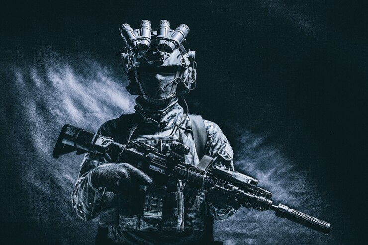 Photo ハーフレングス、陸軍兵士の控えめなスタジオ撮影、マスクの海洋歩兵、迷彩服、装備された現代の弾薬、ヘルメットに暗視装置を備えた暗闇に立っている武装したサービスライフル