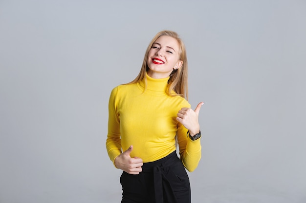 Half- length portrait of joyful  girl showing thumb up