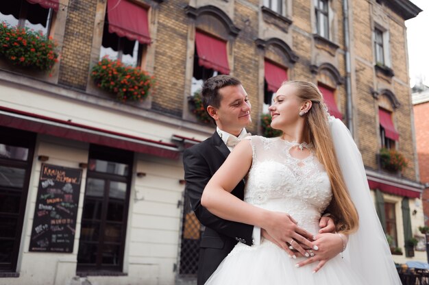 Half length shot of a groom embracing the bride 