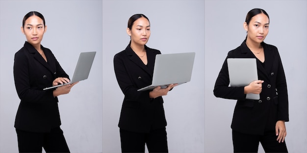 Half lichaamsportret van het zwarte formele kostuumjasje van de jaren '20 Aziatische vrouw. Office vrouw draagt notebook laptop glimlach over grijze achtergrond geïsoleerd