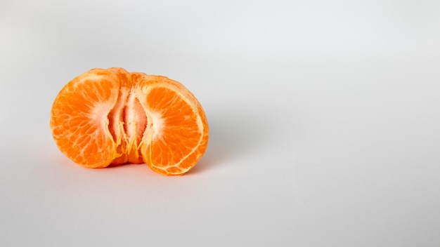 A half of an orange is on a white surface.