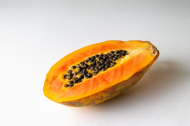 Half of papaya lies on a white background