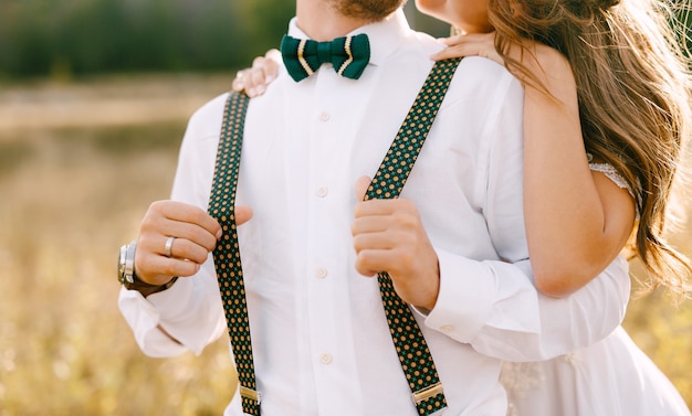 Half portrait of bride hugging groom from behind bride in a beautiful white dress groom in white