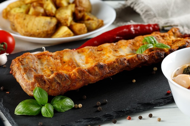 Half rack of barbecue pork ribs with fries potatoes