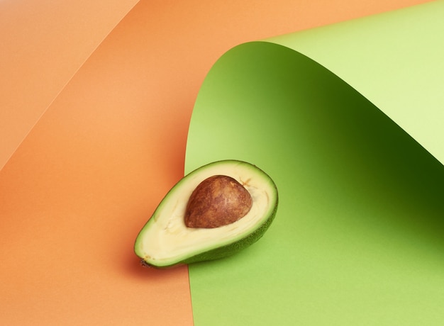 Half rijpe groene avocado met een bruin bot