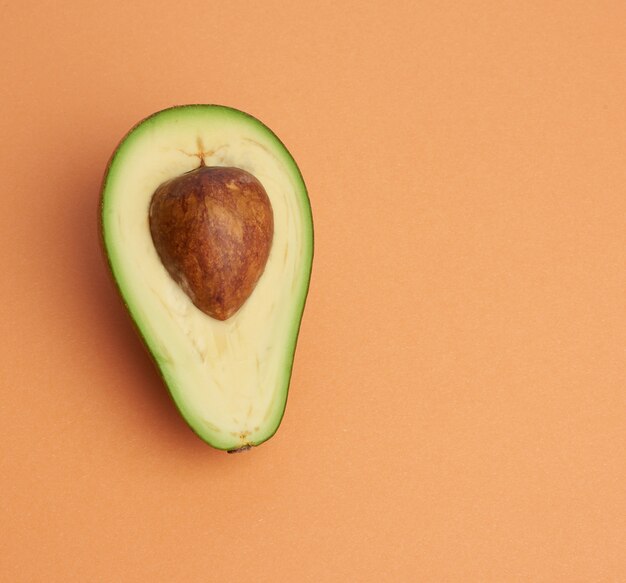 Half ripe green avocado with a brown bone