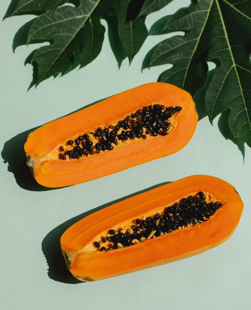 Half of ripe papaya fruit with seeds on a color background appetizing tropical fruit