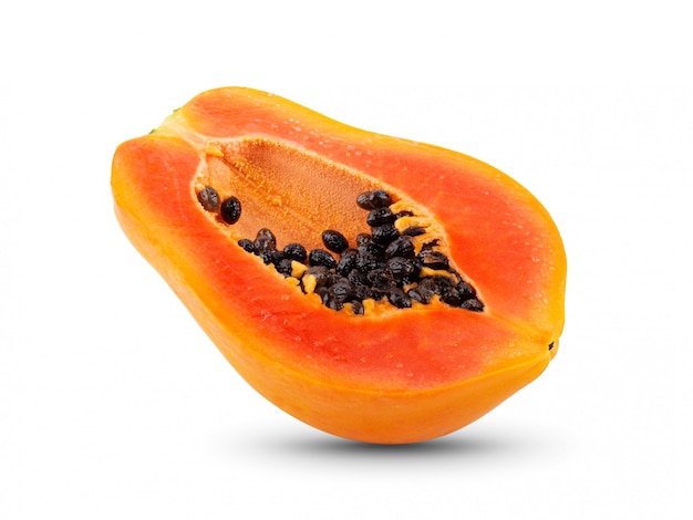 Half of ripe papaya fruit with seeds on white wall