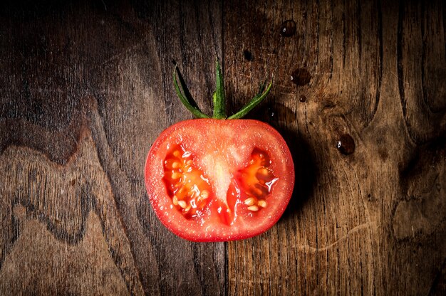 Photo half tomato on wood