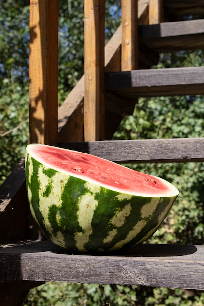 Half watermelon on wooden stairs, close up