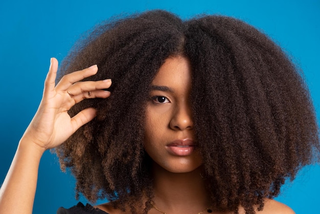 halfclosed portrait of beautiful young woman touching black power hair