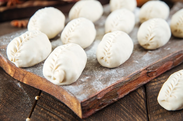 Halffabrikaten manti knoedels op de houten plank