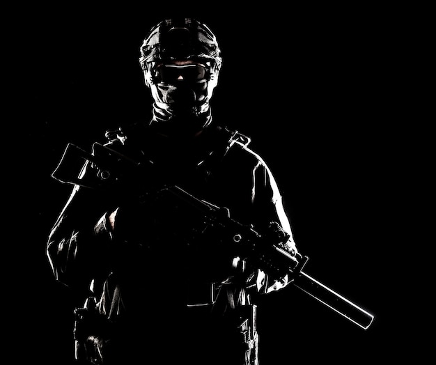 Halflang portret van special forces-soldaat, legercommando, tactisch politieteam of SWAT-jager met verborgen achter masker en brilgezicht, gewapend aanvalsgeweer met geluiddemper, rustige studio-opname
