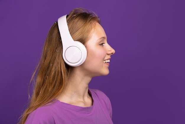 Halflength portrait of young beautiful smiling girl isolated on purple studio background concept of