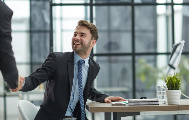 Hallo door Man in Office Indoor Wuivende Hand