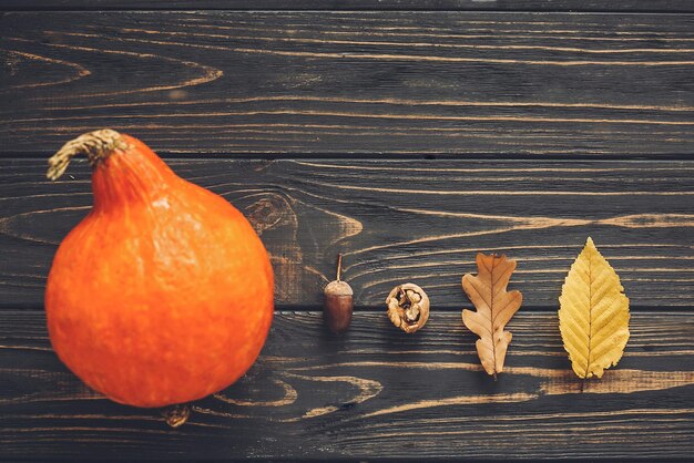 Hallo herfst mooie pompoen met heldere herfstbladeren eikels noten op houten rustieke tafel Happy Thanksgiving concept plat lag Ruimte voor tekst Herfst seizoen wenskaart