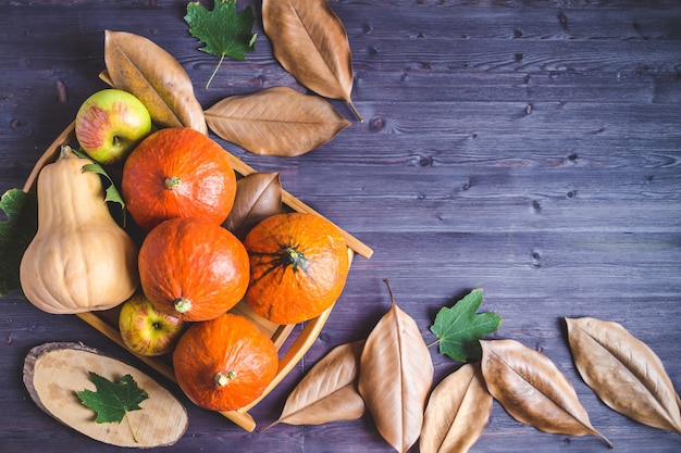 Hallo herfst. Oranje pompoenen Appels Herfst gebladerte op een houten achtergrond