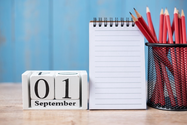 Hallo septemberkalender, welkom terug naar school met notitieboekje en potloden. kopieer ruimte voor tekst