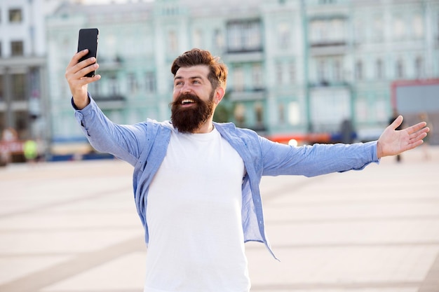 Hallo Wereld. Man selfie foto smartphone te nemen. Streaming online videogesprek. Mobiel internet. Toerist legt gelukkig moment vast voor blog. Hipster mobiele telefoon blogger. Blog online inhoud. Persoonlijke blog.