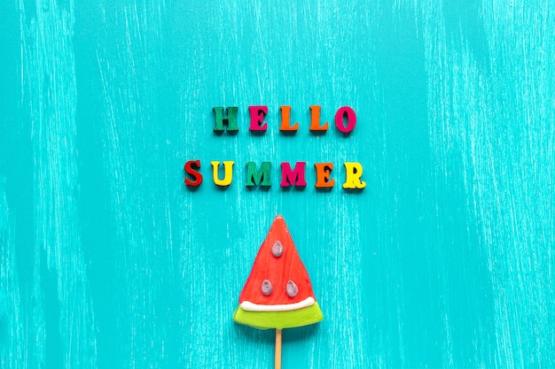 Foto hallo zomertekst en watermeloenlolly op stok. concept creatieve sjabloon wenskaart