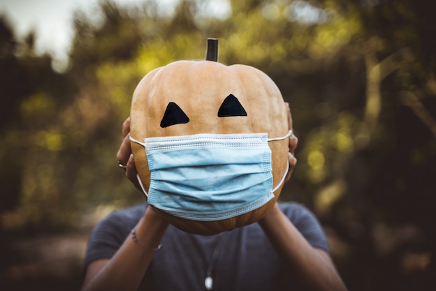 Halloween 2020-pompoen met een masker vanwege de covid 19