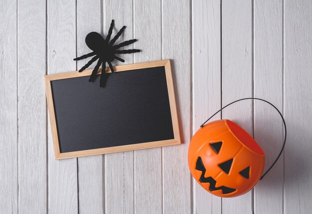 Halloween-achtergrond met Pompoenen, zwarte spin en bord op houten vloerachtergrond