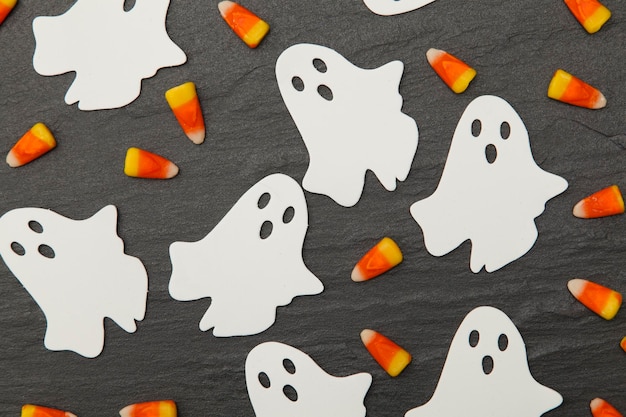 Halloween-achtergrond met spoken en suikergoedgraan op een leiachtergrond