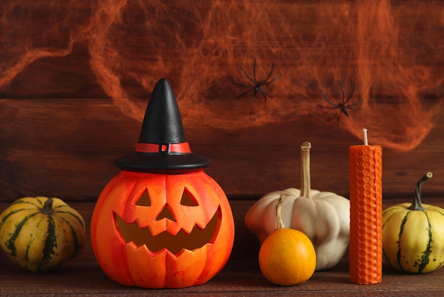 Halloween ansichtkaart Jackolatern met decoratieve pompoenen en kaars tegen spinnenweb met twee spinnen