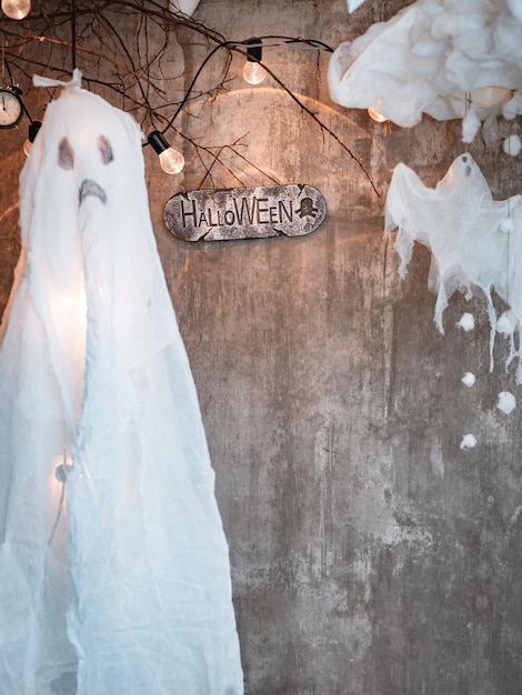 Halloween background on a concrete background with a cast and a sign with an inscription free space for text Diy Halloween ghost of starch and gauze