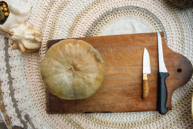 halloween background a pumpkin on a cutting board on a table with copy space