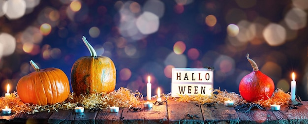 Halloween background Pumpkins and burning candles on wooden table