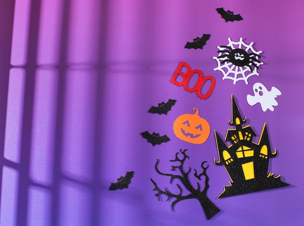 Halloween background on purple background with gradient and\
shadows a haunted house with bats copy space